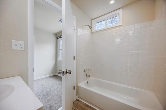 bathroom featuring vanity and tiled shower / bath