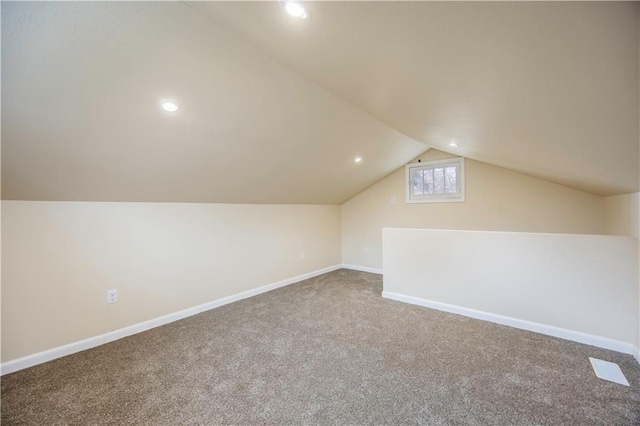 bonus room with carpet flooring and vaulted ceiling