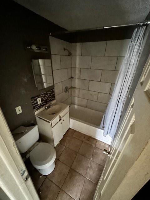 full bathroom featuring tile patterned flooring, toilet, decorative backsplash, vanity, and shower / tub combo