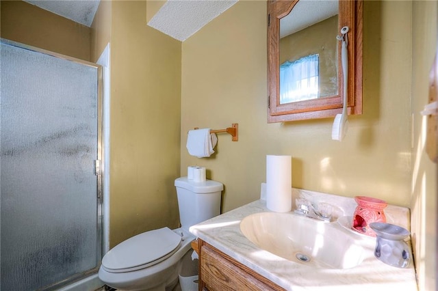 bathroom featuring toilet, a textured ceiling, an enclosed shower, and vanity