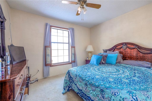 carpeted bedroom with ceiling fan and a textured ceiling