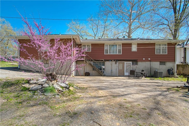 back of house with stairway and central AC