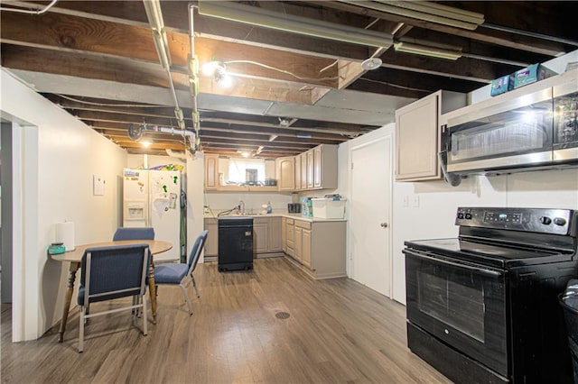 below grade area with a sink, white fridge with ice dispenser, and light wood-type flooring