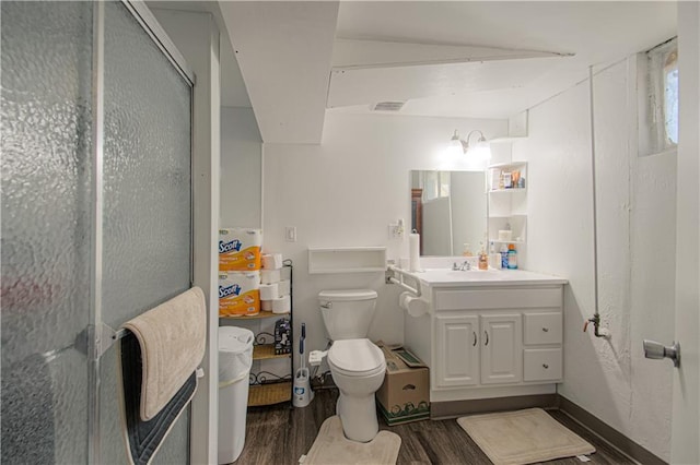 full bath with vanity, toilet, a shower stall, wood finished floors, and visible vents