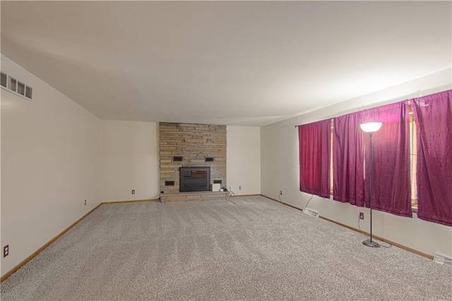unfurnished living room with baseboards, a fireplace, carpet flooring, and visible vents