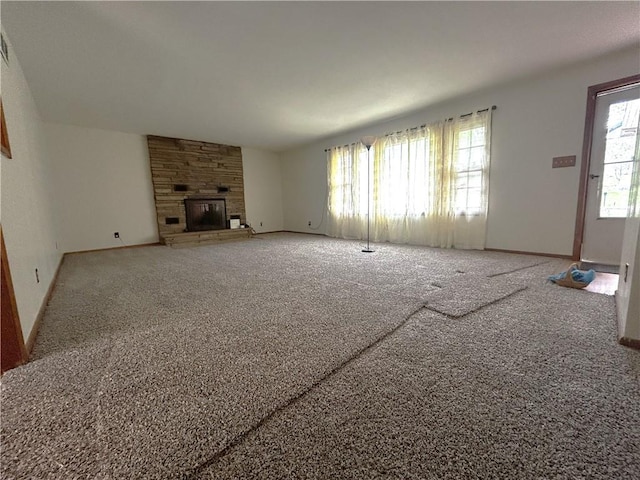 unfurnished living room featuring carpet flooring, baseboards, visible vents, and a fireplace
