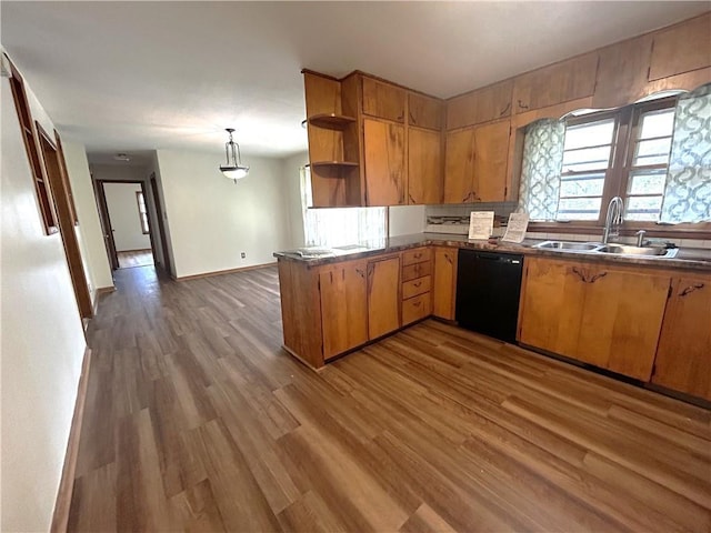 kitchen featuring dark countertops, open shelves, wood finished floors, dishwasher, and a sink