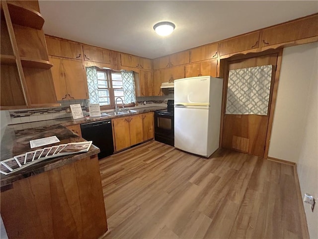 kitchen with open shelves, dark countertops, light wood-type flooring, a sink, and black appliances