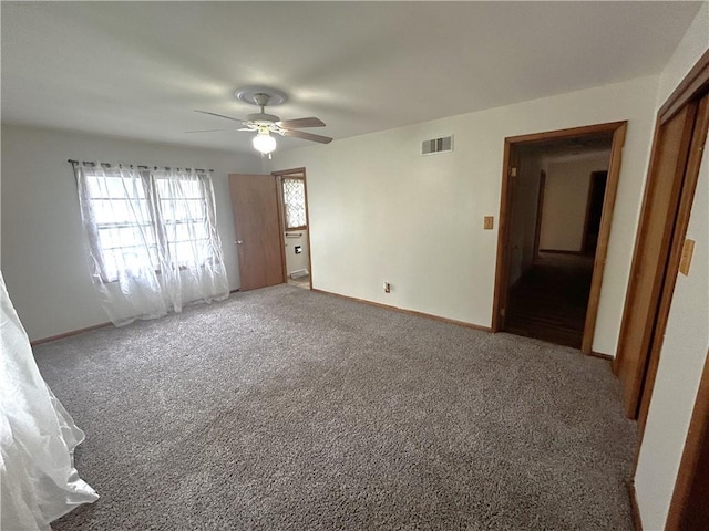 carpeted empty room featuring visible vents, baseboards, and ceiling fan