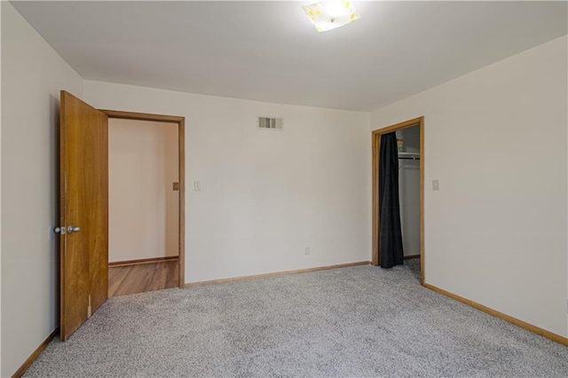 unfurnished bedroom featuring visible vents, carpet, and baseboards