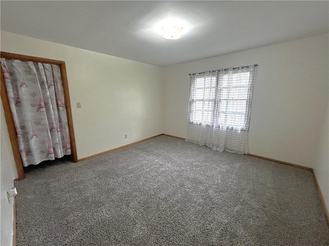 carpeted empty room with baseboards