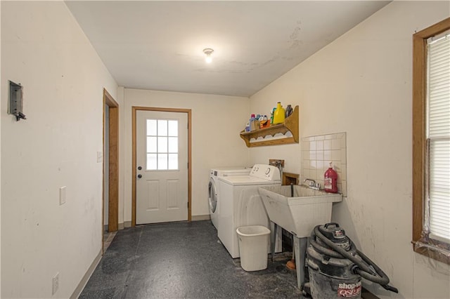 laundry room with laundry area, washing machine and dryer, and baseboards