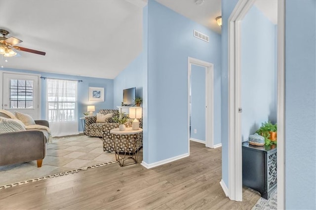 living room featuring vaulted ceiling, ceiling fan, and light hardwood / wood-style floors