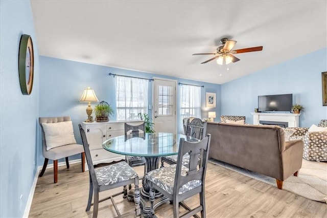 dining room featuring vaulted ceiling, ceiling fan, and light wood-type flooring