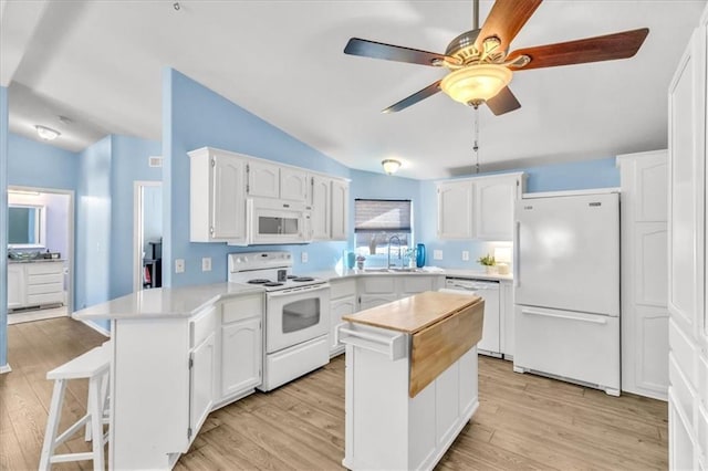 kitchen featuring white cabinetry, sink, white appliances, and a center island