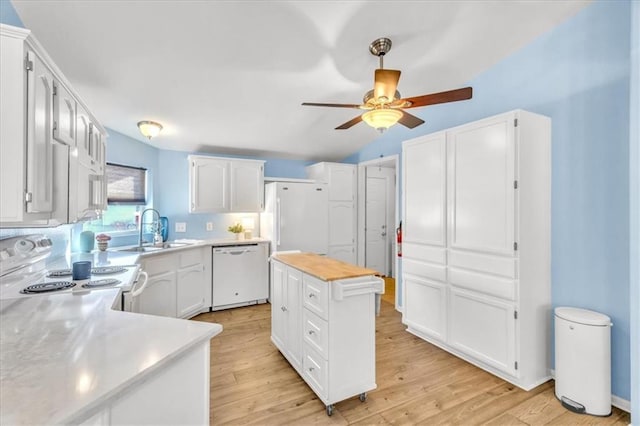 kitchen featuring a center island, sink, white cabinets, and white appliances