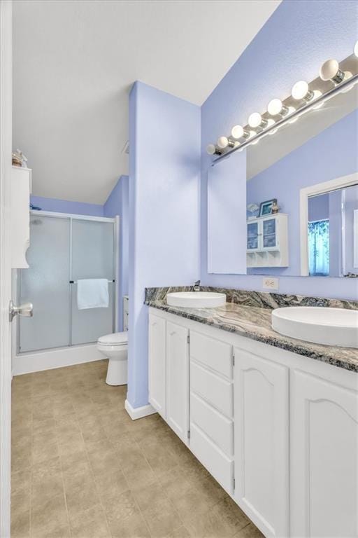 bathroom featuring a shower with door, vanity, lofted ceiling, and toilet