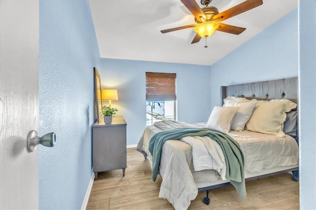 bedroom featuring ceiling fan, vaulted ceiling, and light wood-type flooring