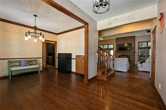 interior space with dark hardwood / wood-style flooring, a fireplace, a textured ceiling, and a chandelier