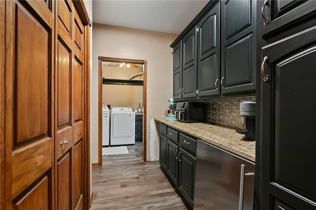 kitchen featuring light stone countertops, backsplash, washer and clothes dryer, and hardwood / wood-style floors