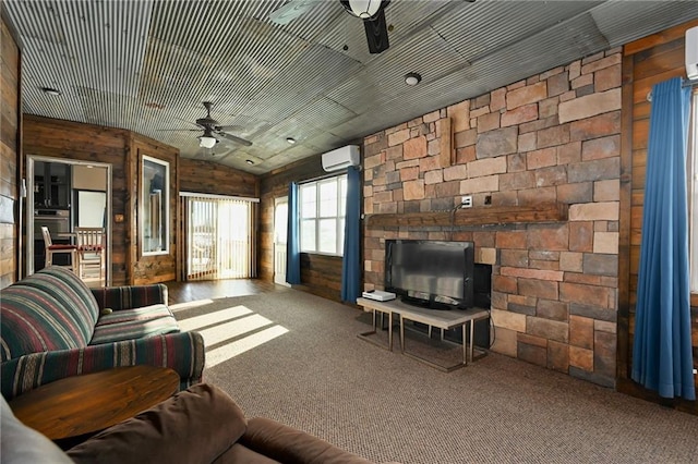 carpeted living room with a wall unit AC, wooden walls, vaulted ceiling, and a stone fireplace