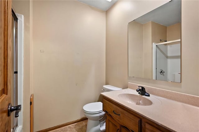 bathroom featuring toilet, tile patterned floors, walk in shower, and vanity