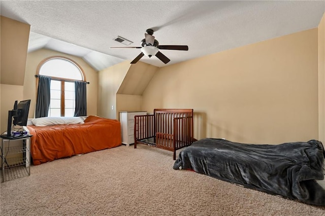 bedroom with a textured ceiling, carpet, ceiling fan, and vaulted ceiling