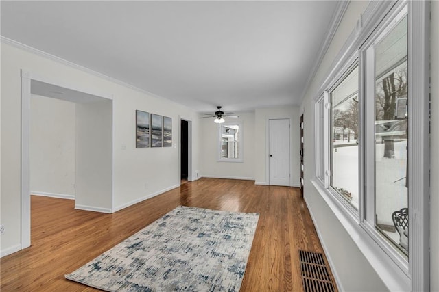 interior space featuring ceiling fan, plenty of natural light, crown molding, and light hardwood / wood-style floors