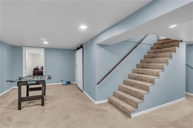 recreation room with a barn door and carpet floors