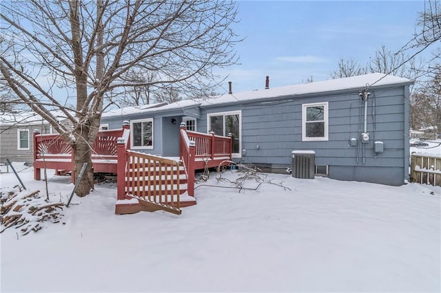 snow covered back of property featuring a wooden deck and cooling unit