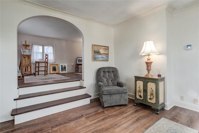 living area with crown molding and hardwood / wood-style floors