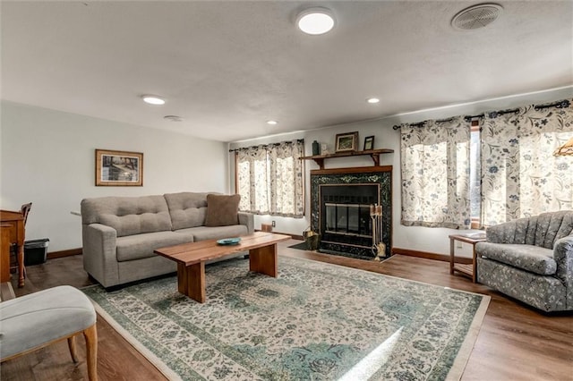 living room with hardwood / wood-style floors and a high end fireplace