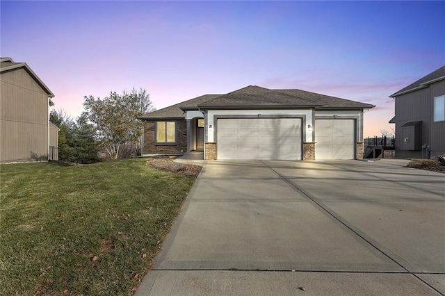 prairie-style house with a yard and a garage