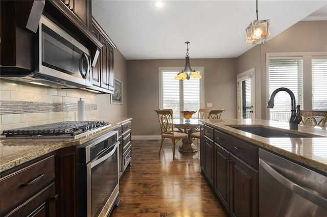 kitchen featuring dark wood-type flooring, pendant lighting, stainless steel appliances, and sink