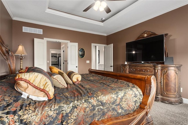 carpeted bedroom with a raised ceiling, ceiling fan, and ornamental molding