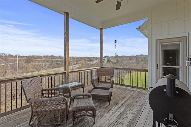 wooden deck with outdoor lounge area and ceiling fan