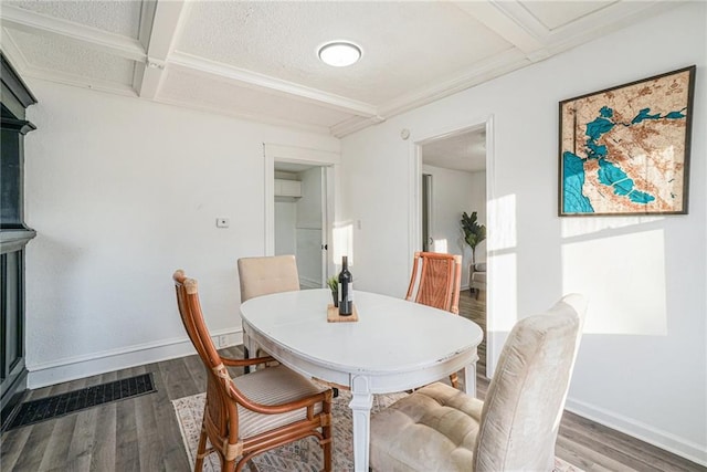 dining room featuring beam ceiling, a textured ceiling, hardwood / wood-style flooring, and coffered ceiling