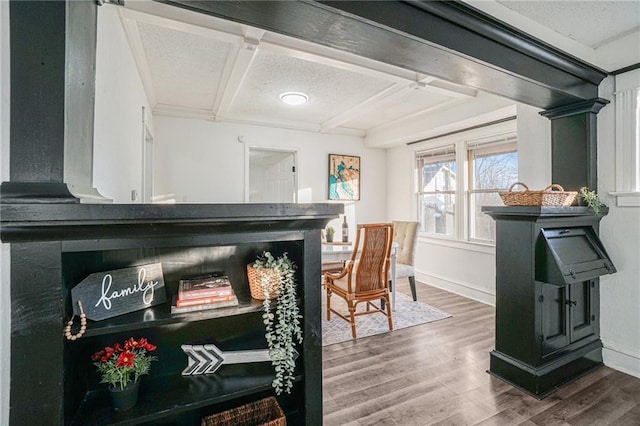 interior space featuring hardwood / wood-style floors, beam ceiling, a textured ceiling, and coffered ceiling