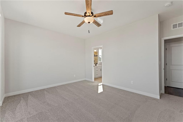 unfurnished bedroom featuring light carpet, baseboards, visible vents, and ensuite bathroom