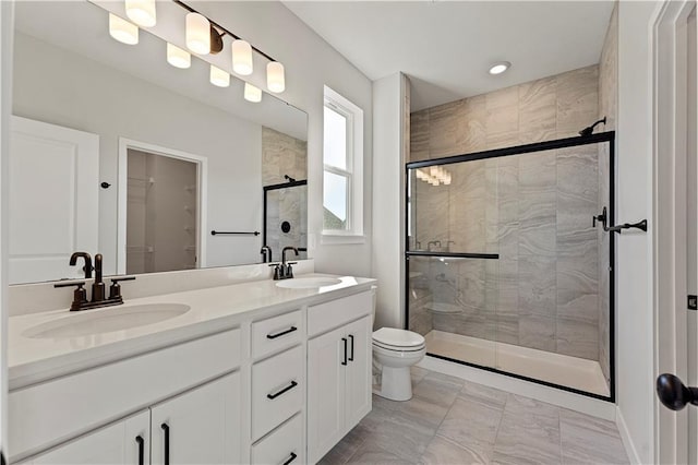 bathroom with a shower with shower door, toilet, and vanity