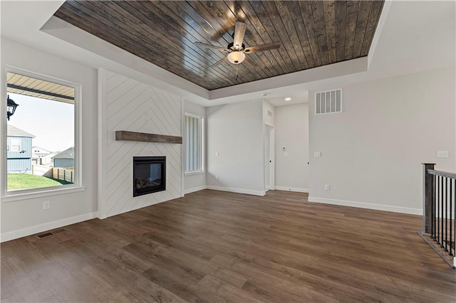 unfurnished living room featuring a fireplace, wood ceiling, visible vents, baseboards, and a tray ceiling