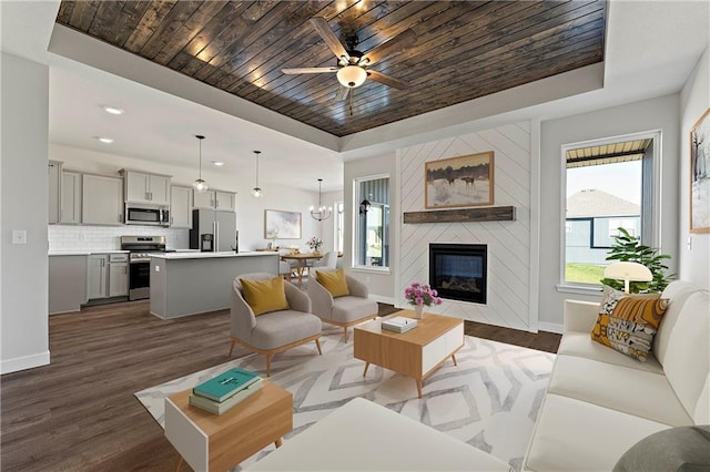 living area with baseboards, wood ceiling, a tray ceiling, and dark wood-type flooring