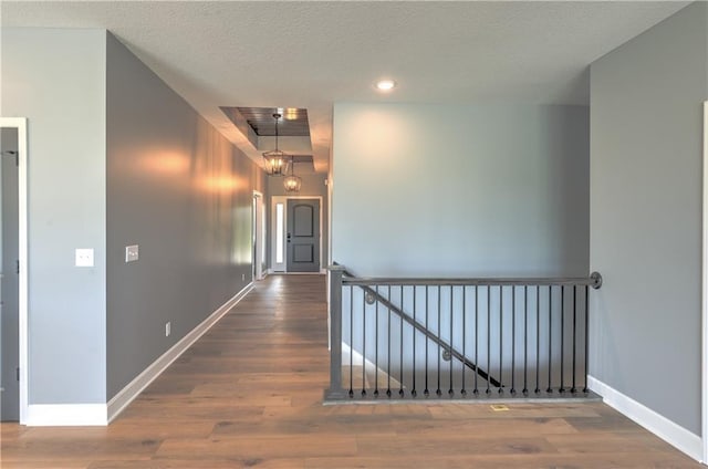 hall with recessed lighting, baseboards, a textured ceiling, and wood finished floors