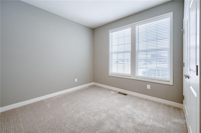 empty room featuring visible vents, baseboards, and carpet flooring