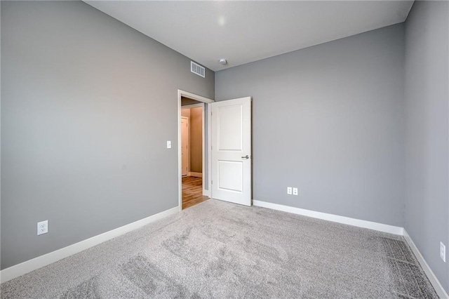 spare room featuring carpet, baseboards, and visible vents