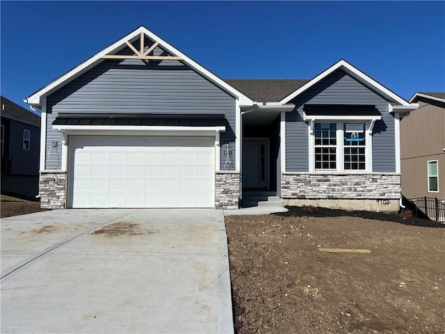 view of front facade featuring a standing seam roof, stone siding, concrete driveway, and a garage