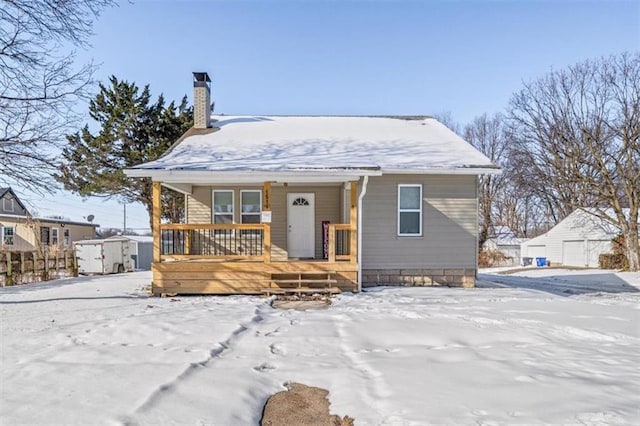 view of front of house featuring a porch and a storage unit