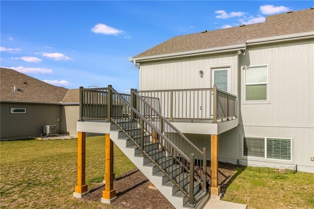 rear view of property with a yard and central air condition unit