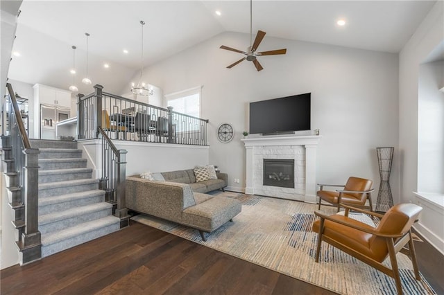 1116 SW Whispering Willow Way, Lees Summit, MO 64064 - living room featuring stairway, wood finished floors, a ceiling fan, high vaulted ceiling, and a stone fireplace