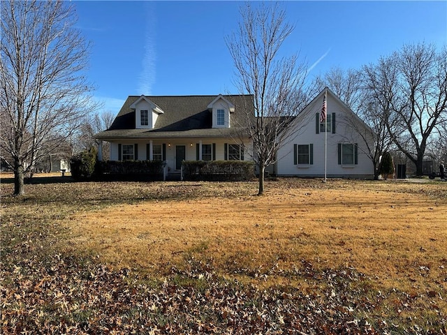 new england style home with a front yard and a porch